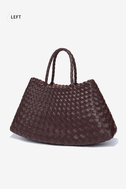 Woman holding brown woven tote bag