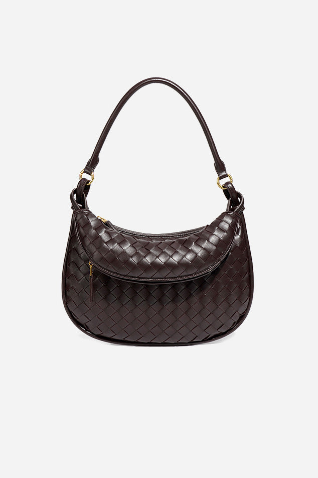 Woman holding dark brown woven leather hobo bag