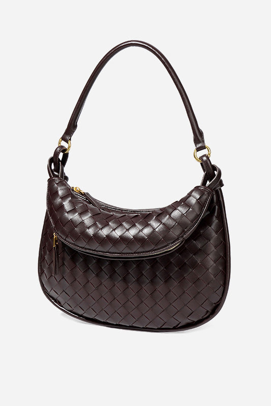 Woman holding dark brown woven leather hobo bag