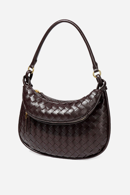 Woman holding dark brown woven leather hobo bag