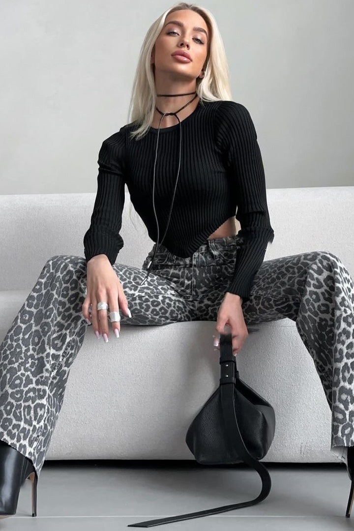 Woman in gray leopard print wide leg jeans and white ribbed knit top