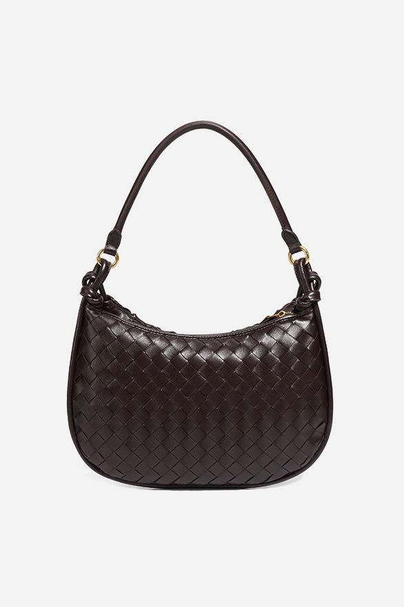 Woman holding dark brown woven leather hobo bag