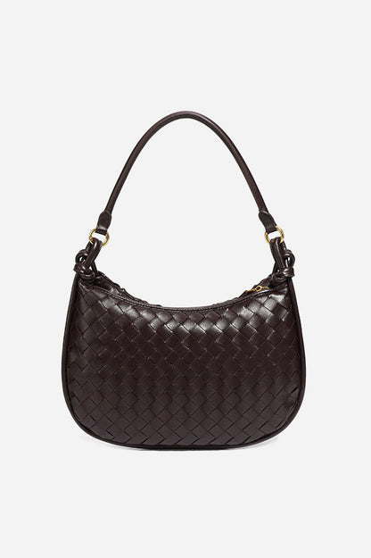 Woman holding dark brown woven leather hobo bag