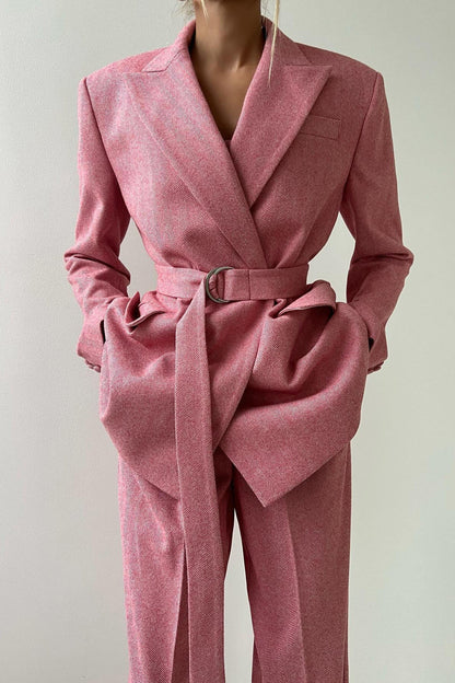 Woman in gray herringbone corset top, wide leg pants, and blazer