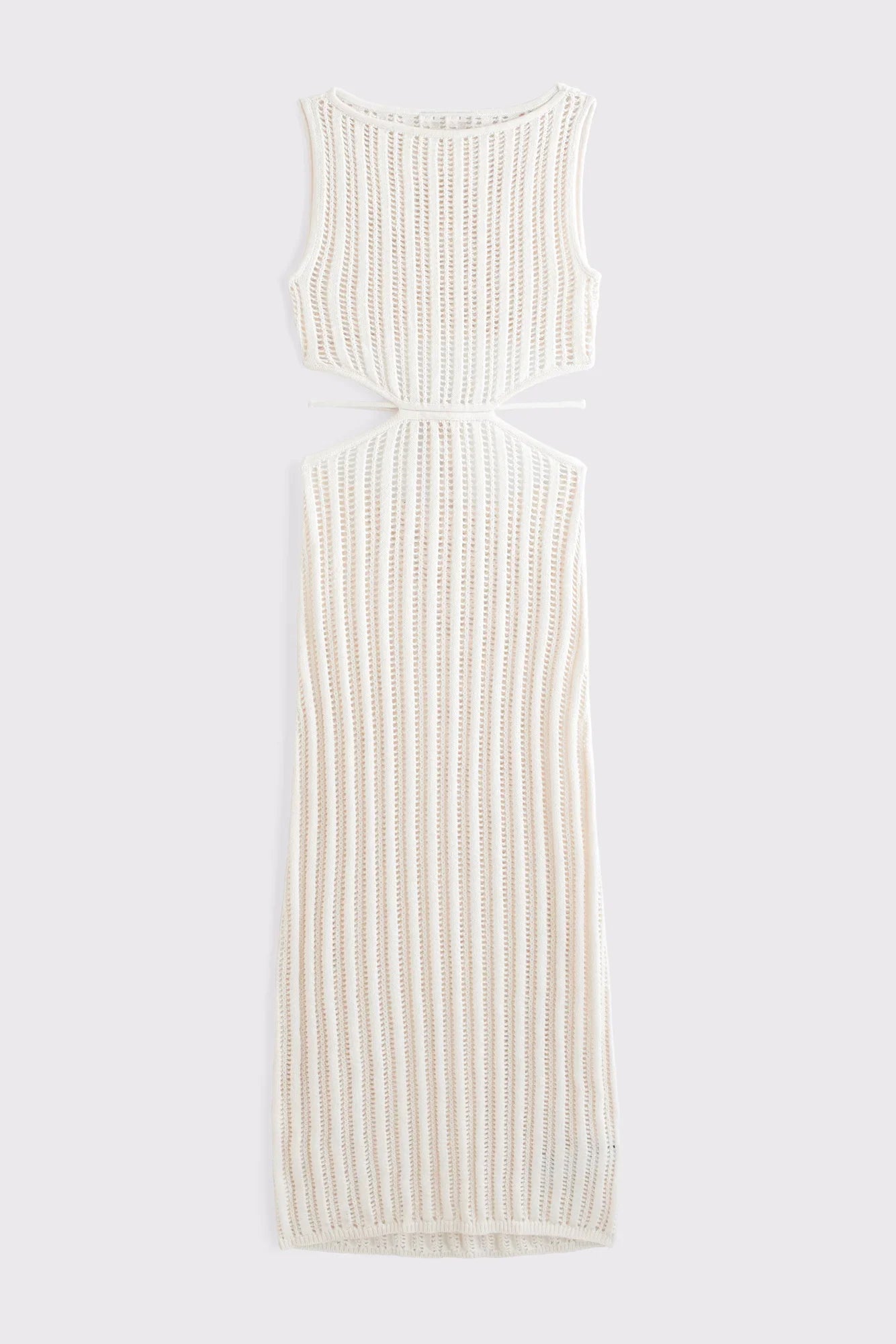 Woman wearing a long, off-white crochet knit dress with waist cutouts.