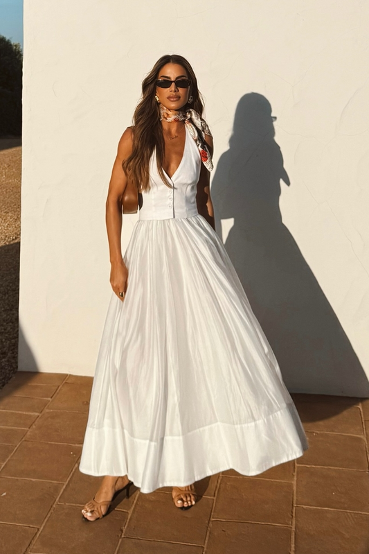 Woman in white linen maxi dress with brown bag and sunglasses