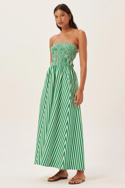 Woman in green and white striped strapless maxi dress holding straw tote bag