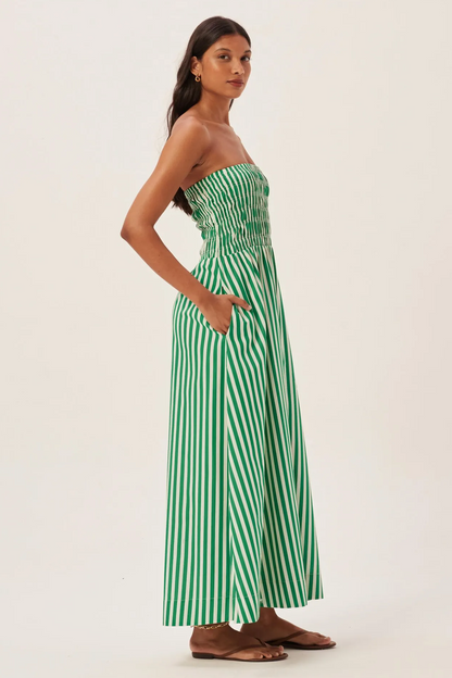 Woman in green and white striped strapless maxi dress holding straw tote bag