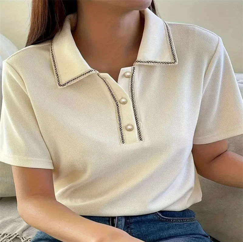 Woman wearing off-white ribbed knit polo shirt with pearl buttons.