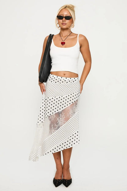 Woman in white tank top and polka dot and lace asymmetrical skirt