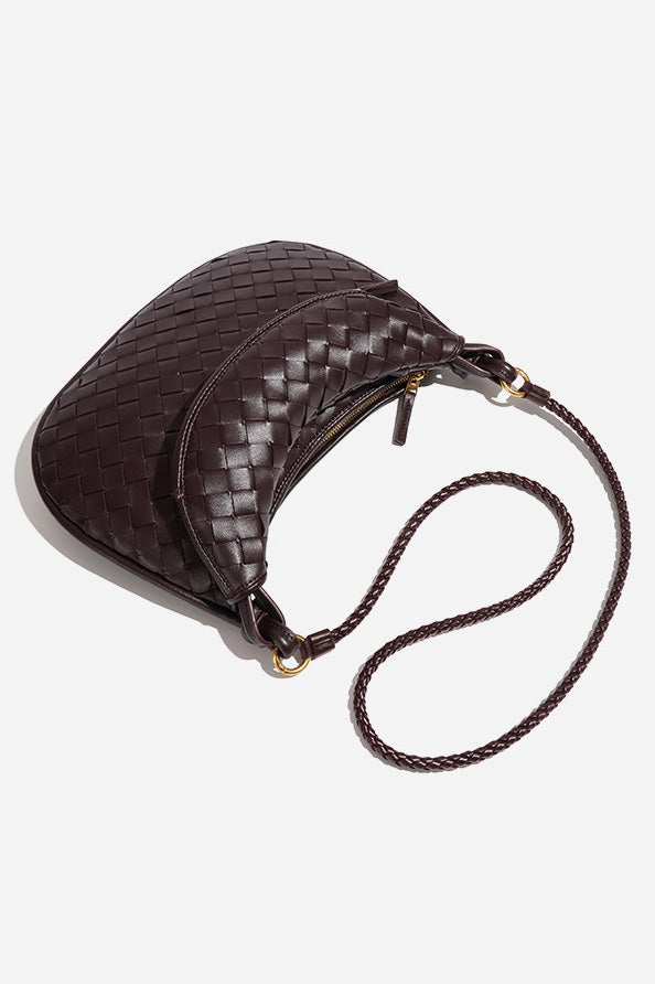Woman holding dark brown woven leather hobo bag