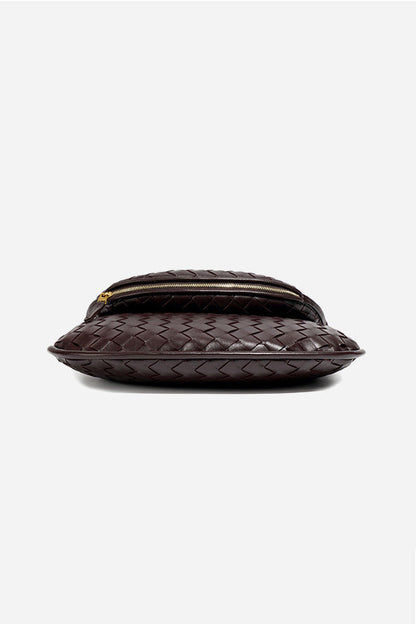 Woman holding dark brown woven leather hobo bag
