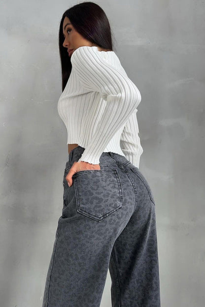 Woman in gray leopard print wide leg jeans and white ribbed knit top