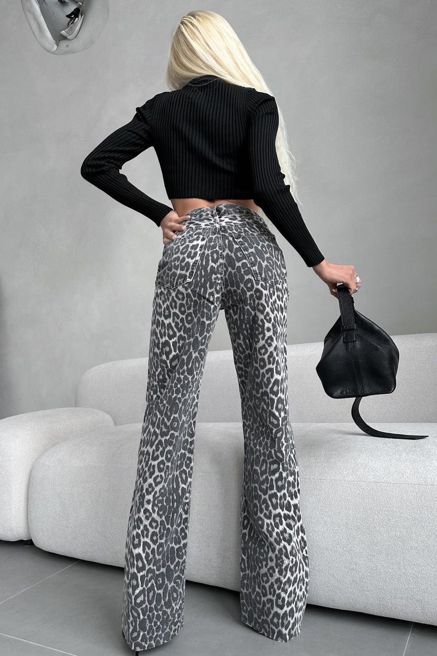 Woman in gray leopard print wide leg jeans and white ribbed knit top