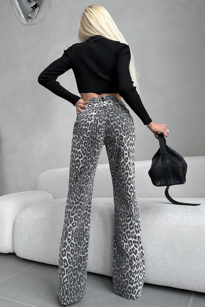 Woman in gray leopard print wide leg jeans and white ribbed knit top