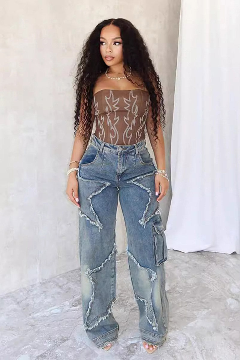 Woman wearing brown sheer corset top and distressed star-detail jeans