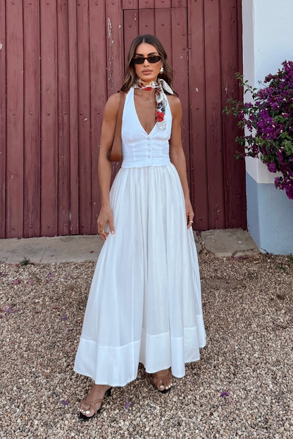 Woman in white linen maxi dress with brown bag and sunglasses