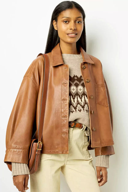 Woman wearing tan leather jacket and patterned sweater