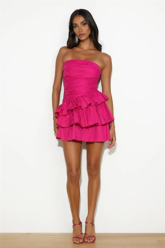 A woman in a hot pink strapless mini dress with a ruffled skirt.