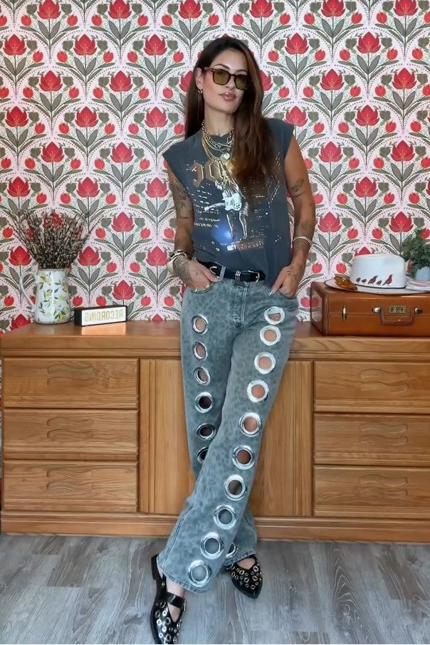 Woman wearing gray acid wash jeans with grommets