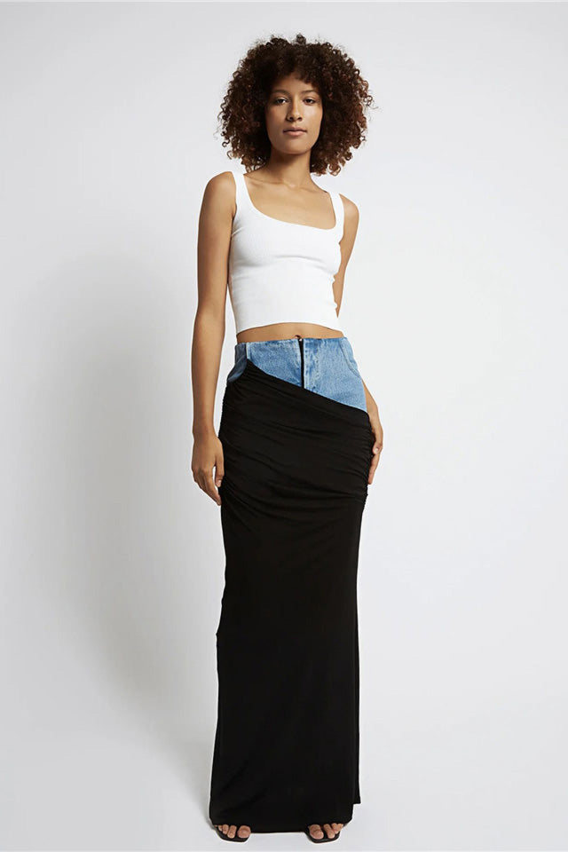 Woman wearing white ribbed tank top and denim/black jersey maxi skirt