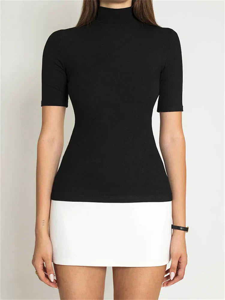 Woman in black ribbed turtleneck and white mini skirt