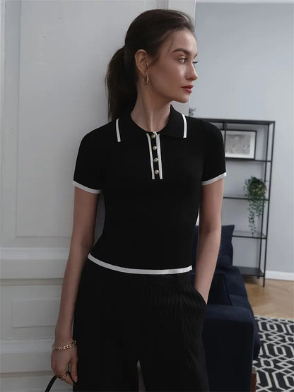 Woman wearing white ribbed knit polo shirt with brown belt and beige trousers