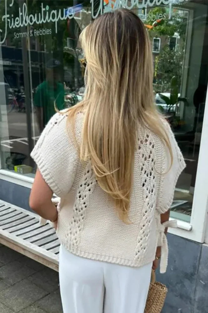 Woman in ivory crochet poncho with patterned pants