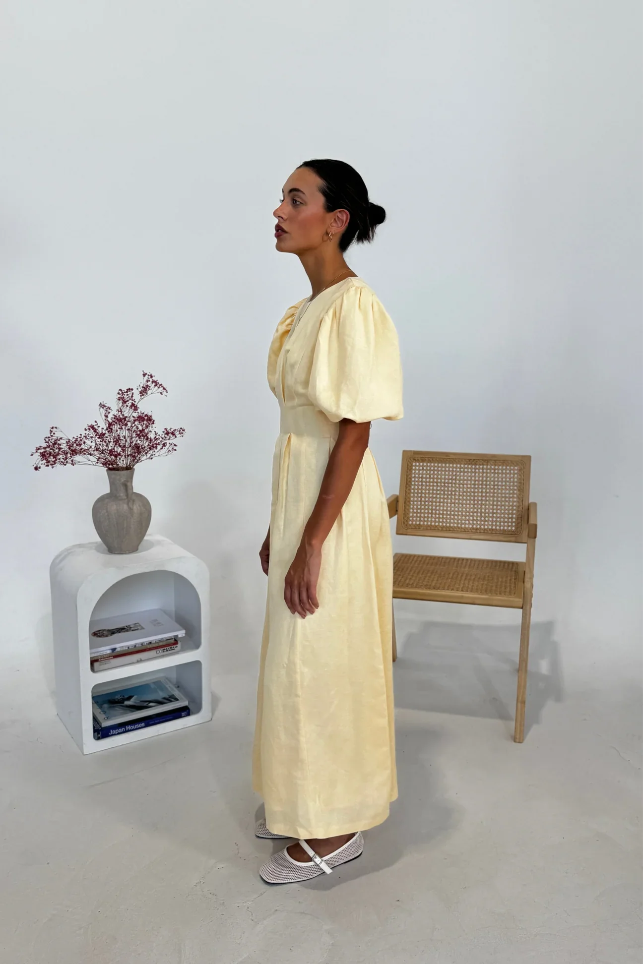 Woman in pale yellow linen maxi dress with puff sleeves