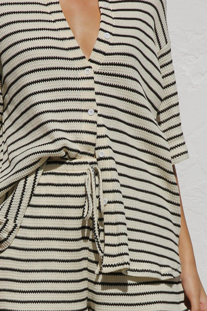 Woman in cream and black striped knit shirt and shorts set
