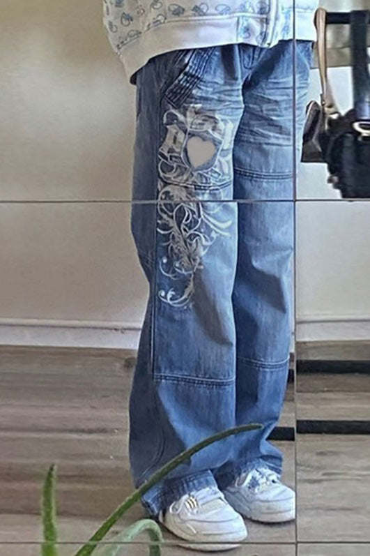 Woman wearing wide leg blue denim jeans with white graphic design