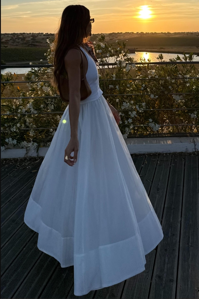 Woman in white linen maxi dress with brown bag and sunglasses