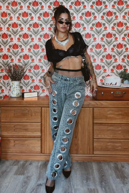 Woman wearing gray acid wash jeans with grommets