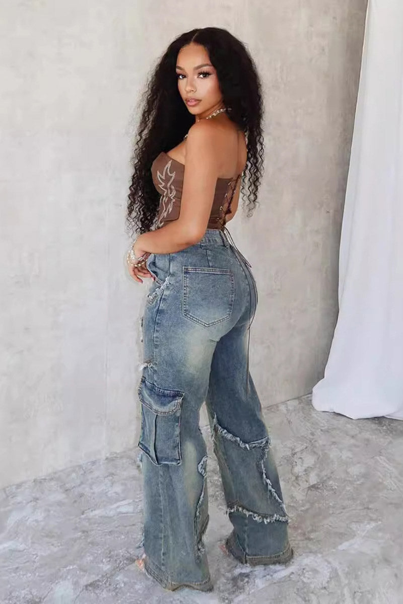 Woman wearing brown sheer corset top and distressed star-detail jeans