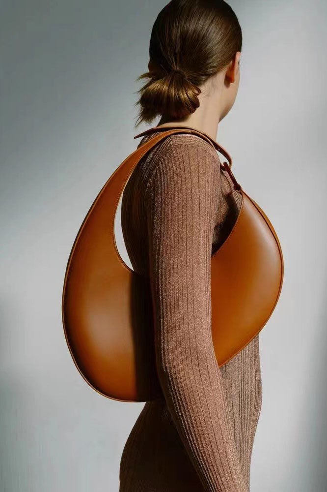 Tan leather crescent-shaped shoulder bag with top handle