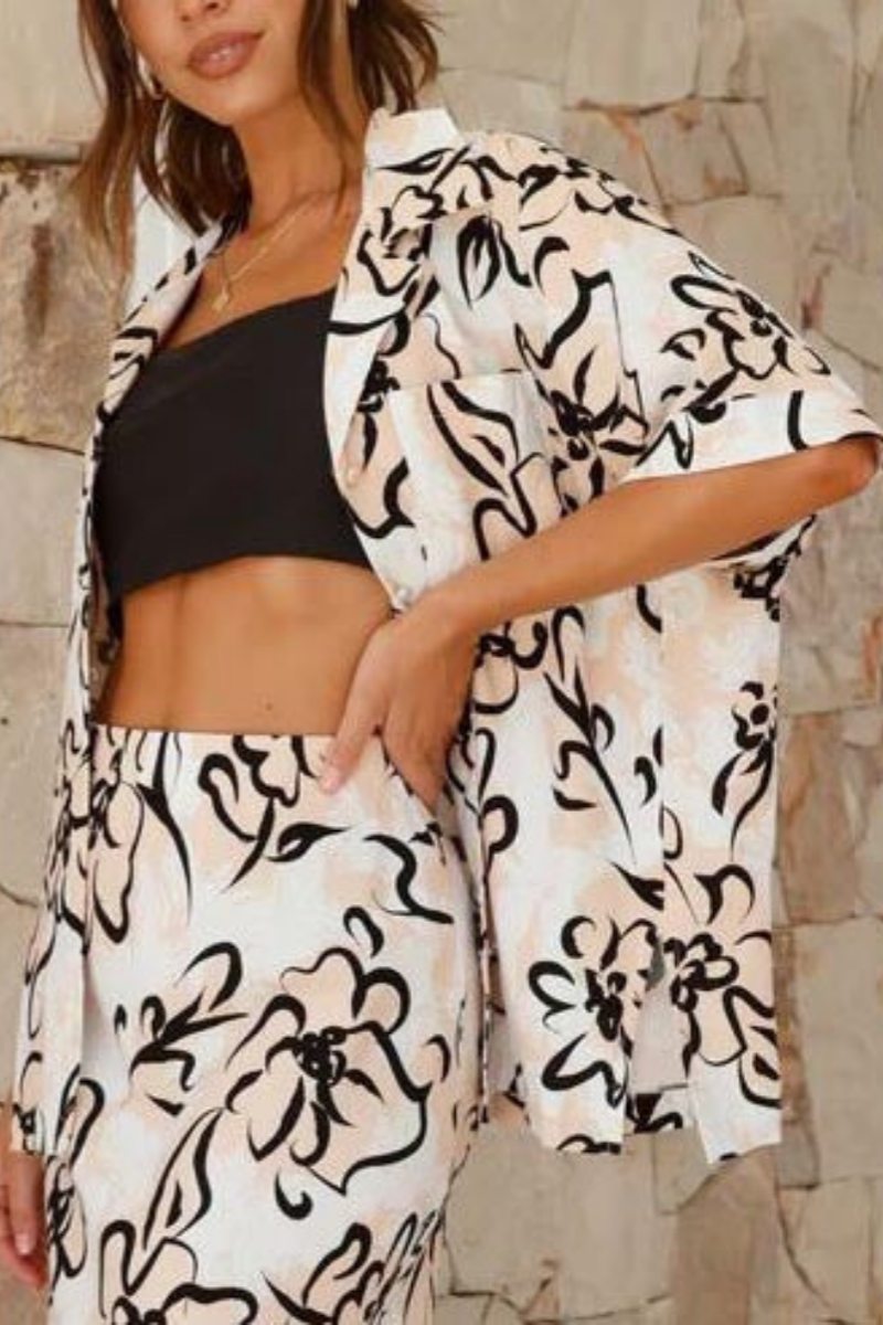 Woman in white linen floral skirt set with black crop top