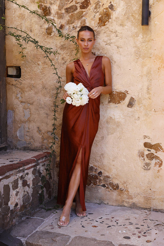Woman in rust satin maxi dress with twisted bodice