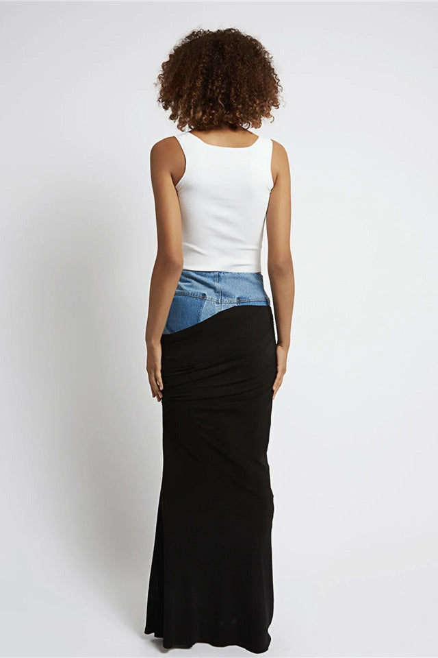 Woman wearing white ribbed tank top and denim/black jersey maxi skirt