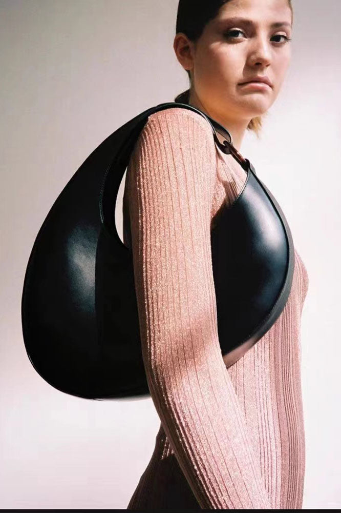 Tan leather crescent-shaped shoulder bag with top handle