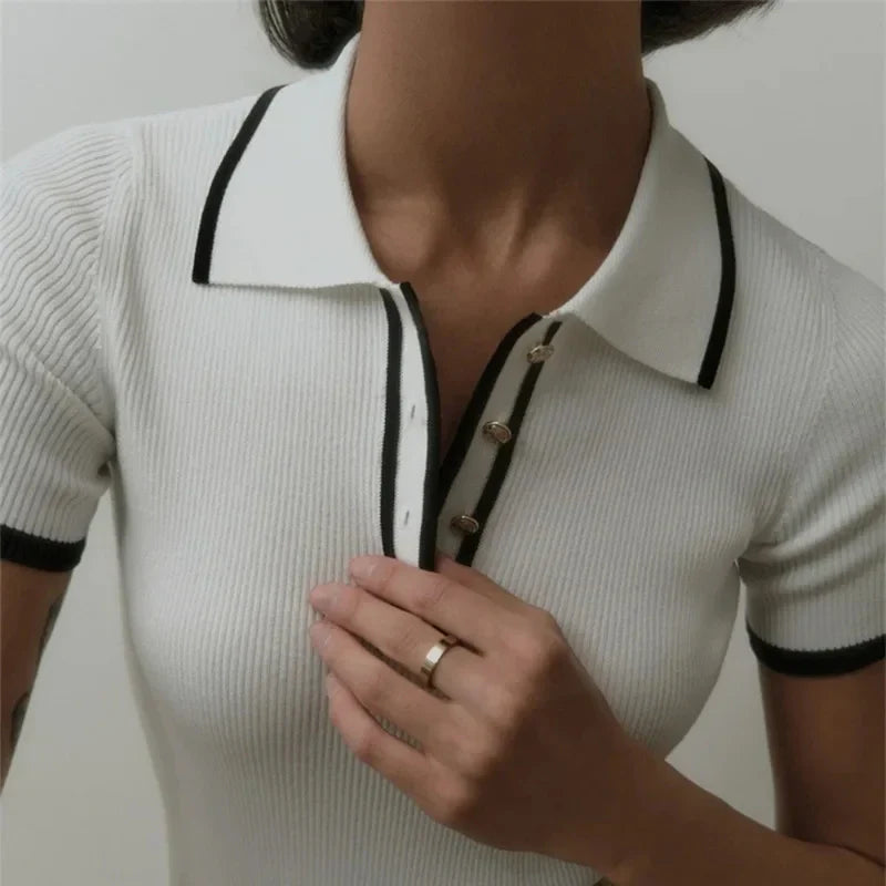 Woman wearing white ribbed knit polo shirt with brown belt and beige trousers