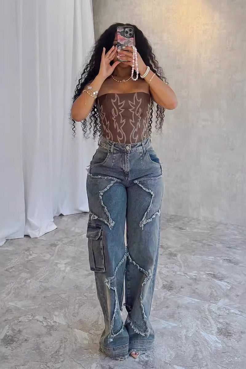 Woman wearing brown sheer corset top and distressed star-detail jeans