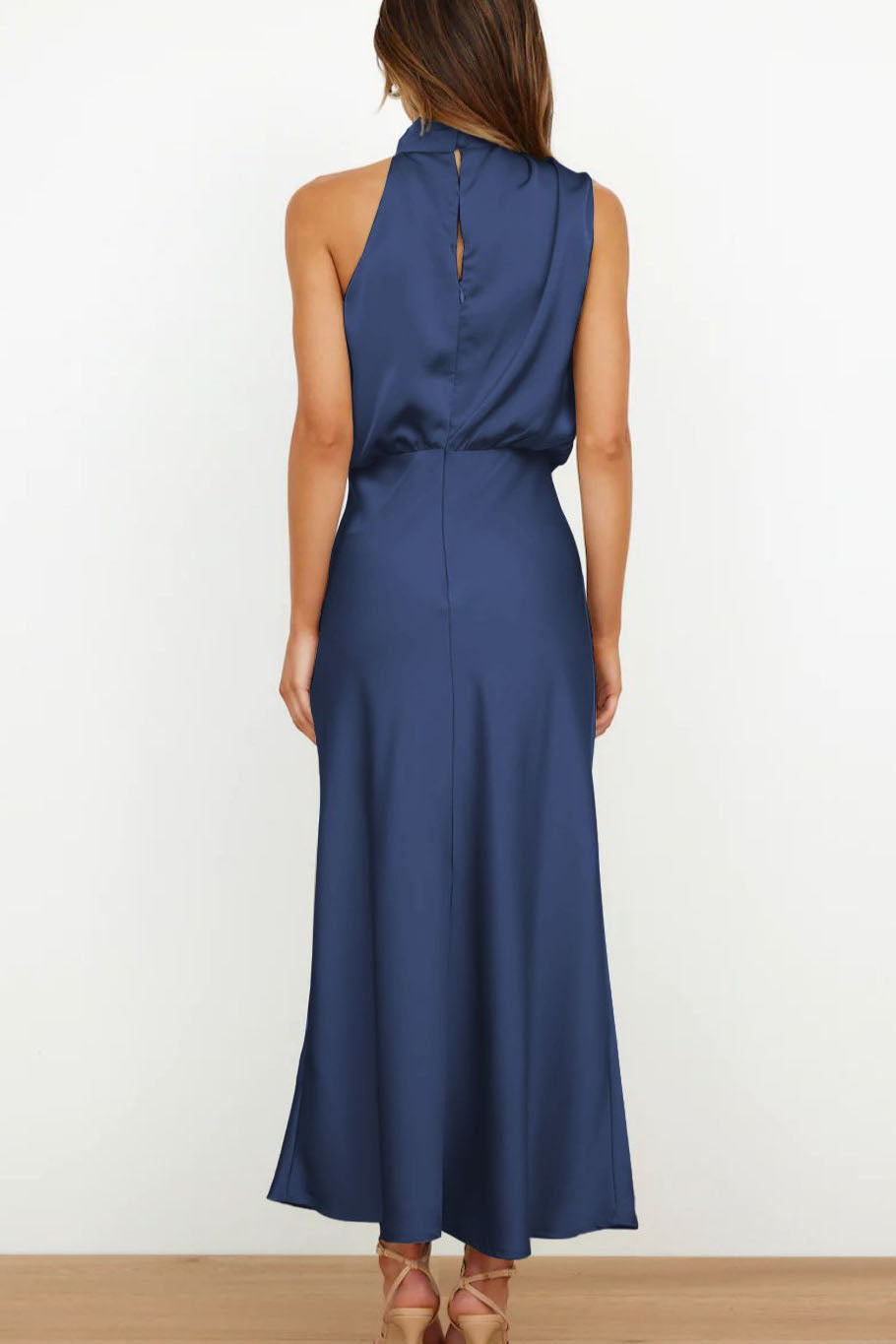 Woman in navy blue satin halter midi dress