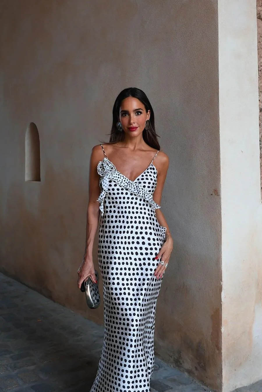 Woman in white satin polka dot dress with ruffle detail