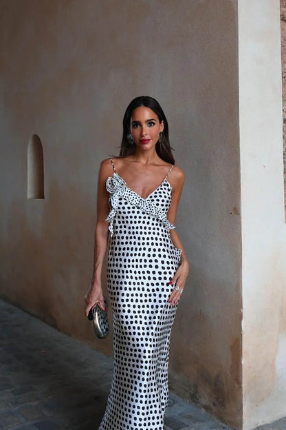 Woman in white satin polka dot dress with ruffle detail