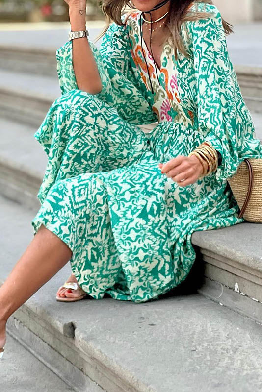 Woman in green and white patterned maxi dress climbing stairs