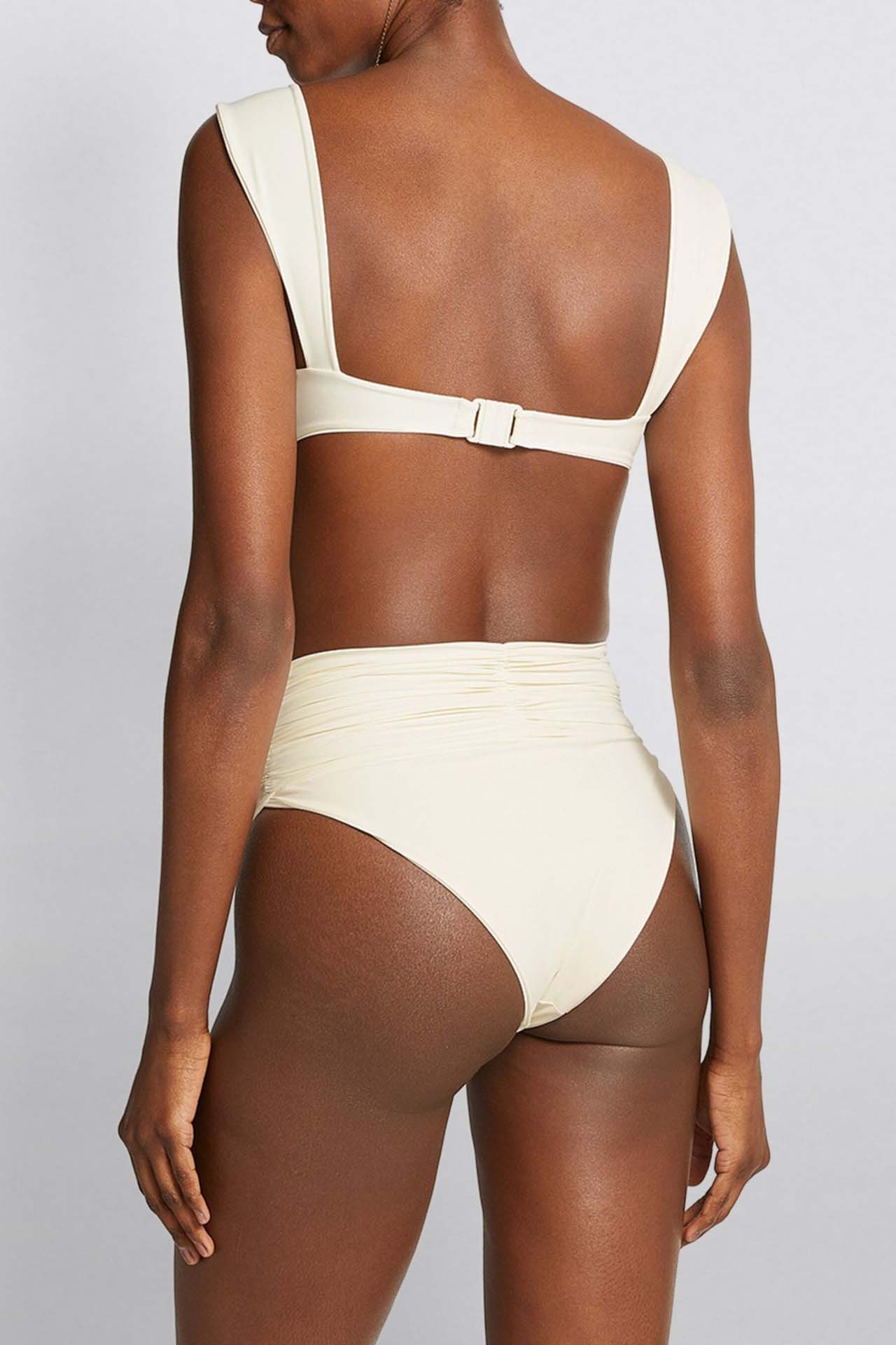 Woman in ivory textured high-waisted swimsuit with large floral detail