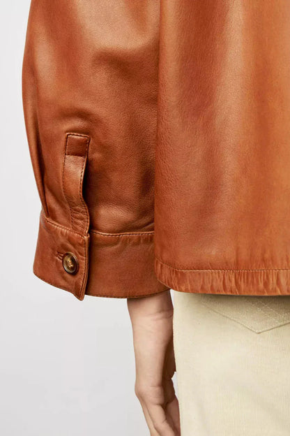 Woman wearing tan leather jacket and patterned sweater