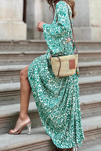 Woman in green and white patterned maxi dress climbing stairs