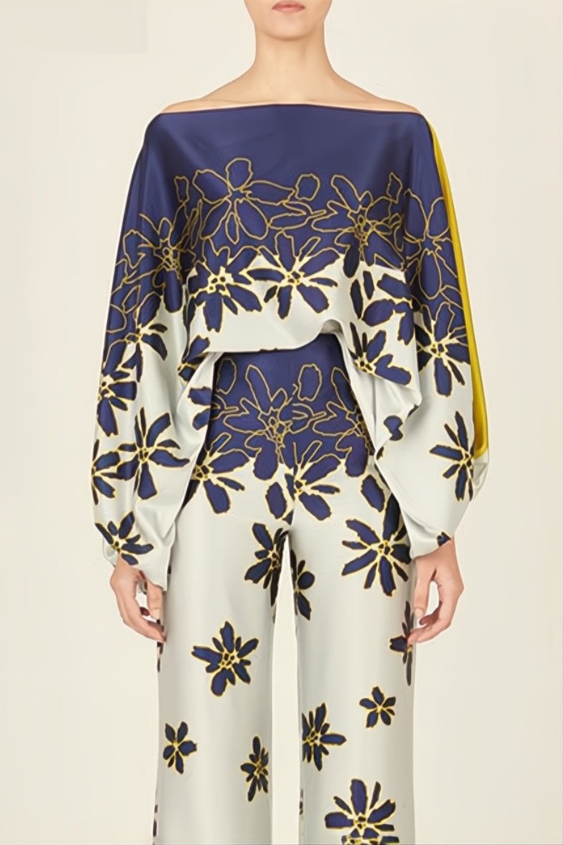 Woman wearing a blue and yellow silk floral print two-piece set.