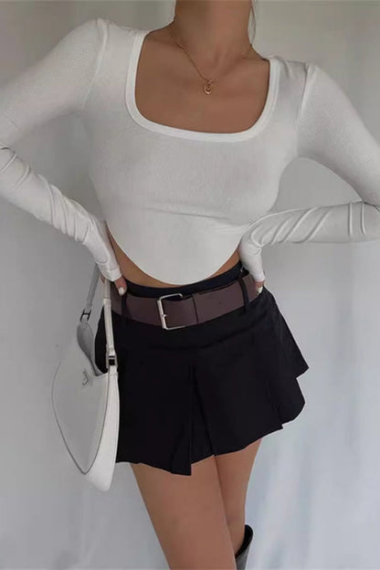 Woman wearing white ribbed crop top and black mini skirt